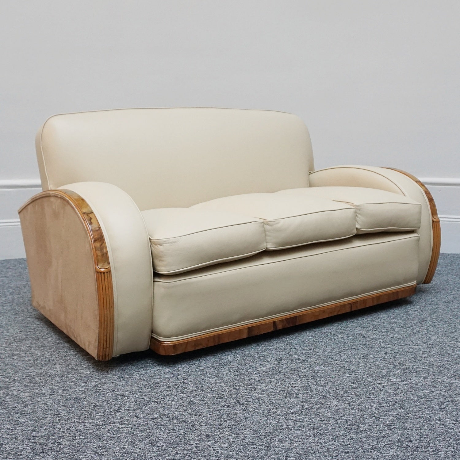 An Art Deco three piece tank suite by Heals of london. Made of Burr and solid walnut banding with reeded lower section, Upholstered in cream leather and contrasting faux suede