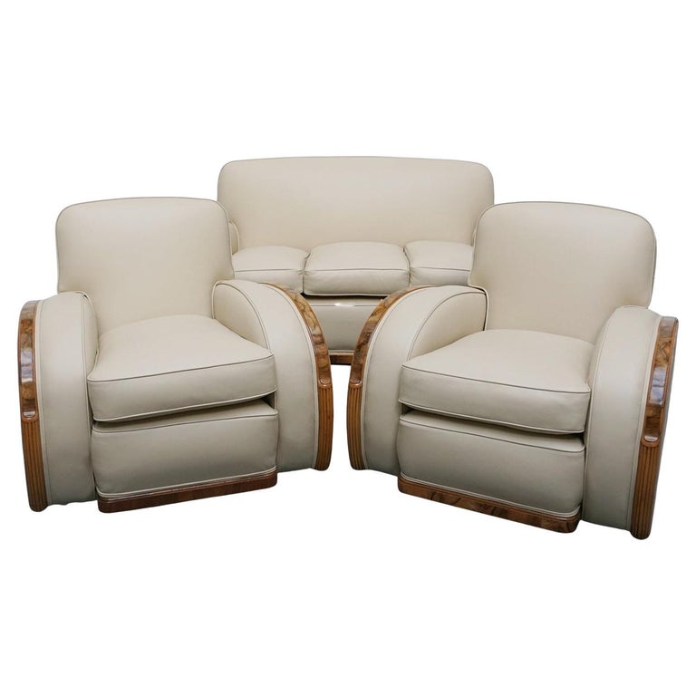 An Art Deco three piece tank suite by Heals of london. Made of Burr and solid walnut banding with reeded lower section, Upholstered in cream leather and contrasting faux suede