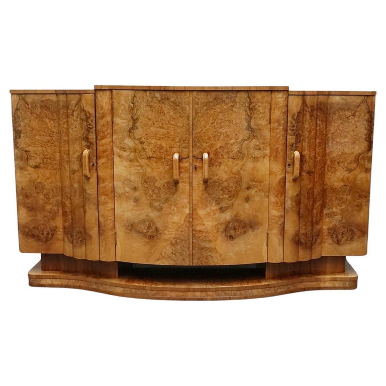 An Art Deco Sideboard by Harry & Lou Epstein with fluted sides set over a curved walnut base made of solid mahogany with burr walnut veneer